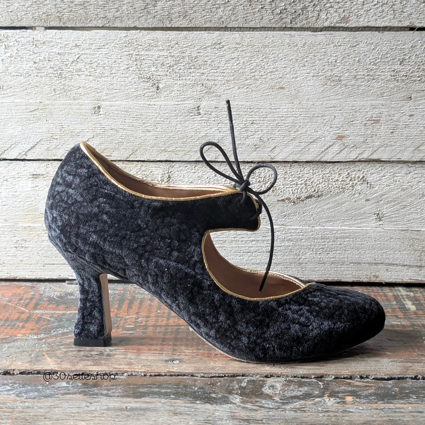 Emily è una scarpa décolleté stringata con tacco cubano di 7 cm realizzata artigianalmente in velluto nero con sinuosa in laminato oro e allacciatura sul collo piede, grintosa ed elegante, un mix di carattere e femminilità.