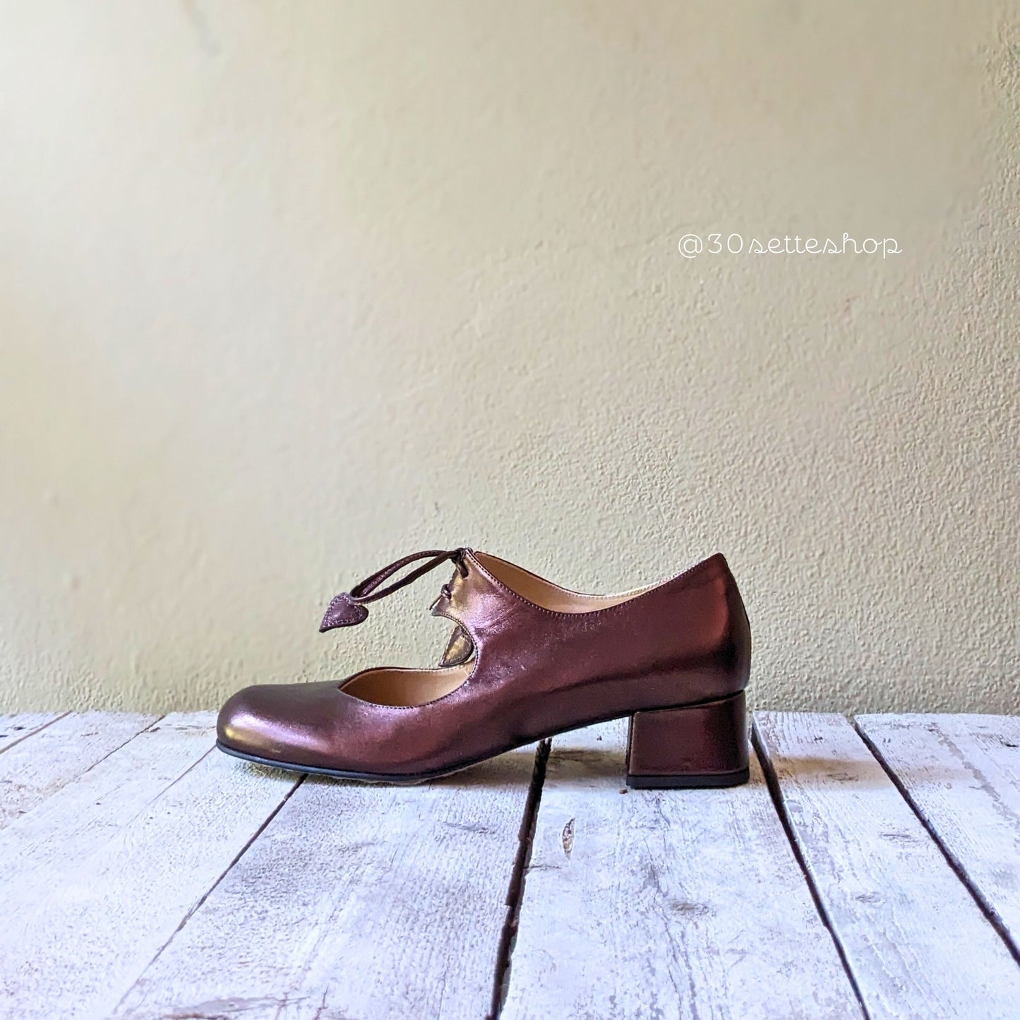 CARPA SCOLLATA E ALLACCIATA IN MORBIDA VERNICE MOKA CHIUSA CON SOTTILI LACCI CHE TERMINANO IN UN CUORE REALIZZATO A MANO.