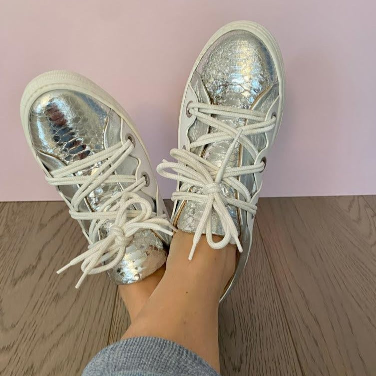 SNEAKERS ALLACCIATA IN MORBIDA NAPPA BIANCA CON BORDATURA E LINGUETTA IN NAPPA ARGENTO LAMINATO A SPECCHIO CON STAMPA PITONE. PASSALACCI IN METALLO ARGENTO SATINATO. FONDO A CASSETTA IN GOMMA COLOR CIPRIA LEGGERISSIMO. FUSSBETT ESTRAIBILE RICOPERTO IN PELLE CON RIALZO INTERNO SUL TALLONE DI 1,5 CM. CALZATA COMODA. SE HAI DUBBI, CONTATTACI VIA SMS O WHATSAPP AL 351/8950405 TI CONSIGLIEREMO NELLA SCELTA. TOMAIA - FODERA - SOTTOPIEDE IN PELLE 100%. PELLAMI ITALIANI DI QUALITÀ. PRODOTTO IN ITALIA, MARCHE