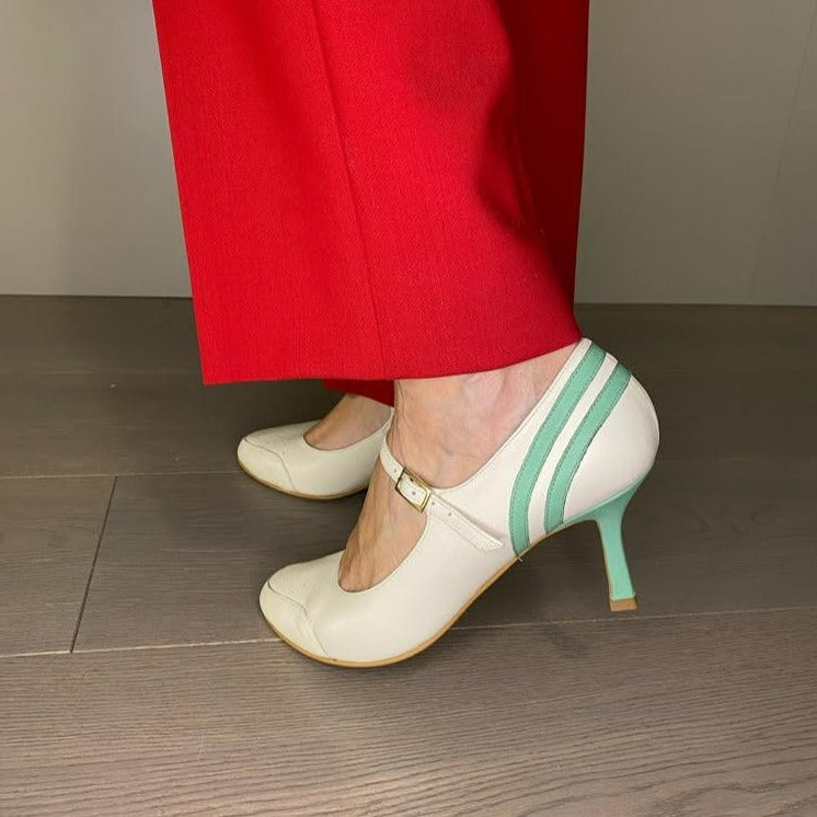 DÉCOLLETÉ BICOLORE IN MORBIDA NAPPA PANNA E DECORAZIONI IN NAPPA ACQUA. PUNTA ROTONDA E UN SOTTILE CINTURINO ALLA CAVIGLIA, MOLTO BON TON, CHE ASSICURA LA SCARPA AL PIEDE NELLA CAMMINATA. CALZATA REGOLARE CHE ABBRACCIA BENE IL PIEDE. SOTTOPIEDE IMBOTTITO DI 3 MM E FODERA IN PELLE. TACCO 7 CM. TOMAIA - FODERA - SOTTOPIEDE IN PELLE 100%. PELLAMI ITALIANI DI QUALITÀ. FONDO CUOIO RIGENERATO. CINTURINO REGOLABILE CON FIBBIA. PRODOTTO IN ITALIA, MARCHE DA HOPE.