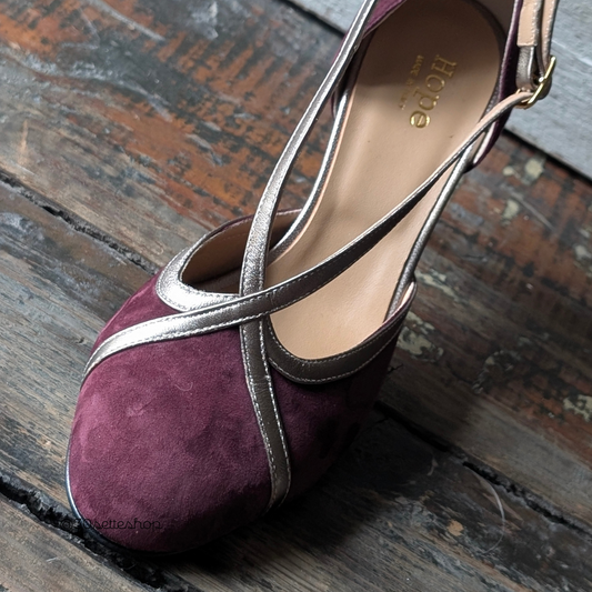 Cristina è una décolleté con tacco di media altezza di 70 mm e cinturino incrociato realizzata artigianalmente in un prezioso pelle scamosciata bordeaux abbinato al laminato beige dei cinturini incrociati sul dorso del piede.