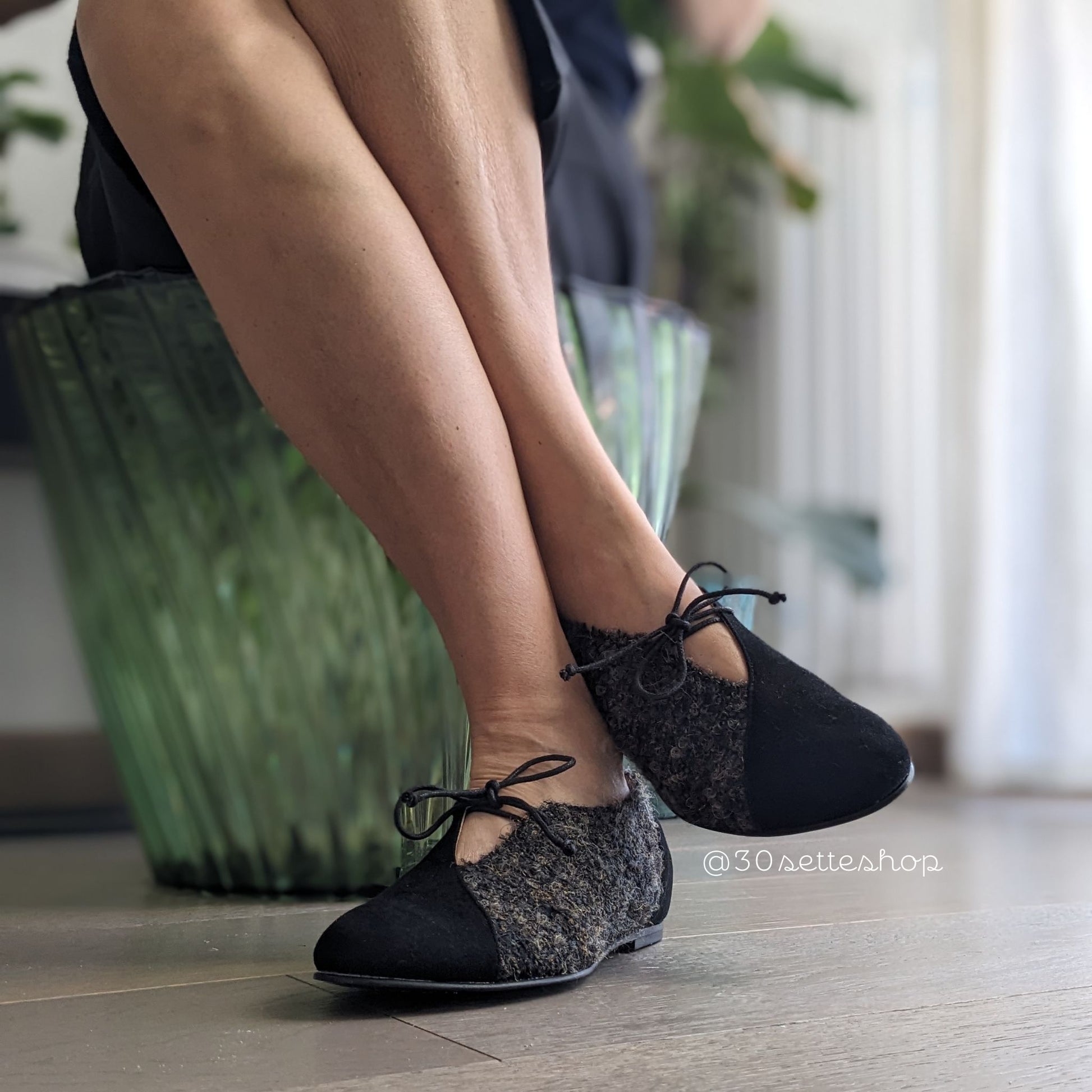 Gilda Ballerina bicolore in camoscio nero e tessuto con punta affusolata, laccio e scollo a v sul dorso del piede. Zeppa interna di 2 cm sul tallone a cui sommare il tacco esterno di 0,8 cm