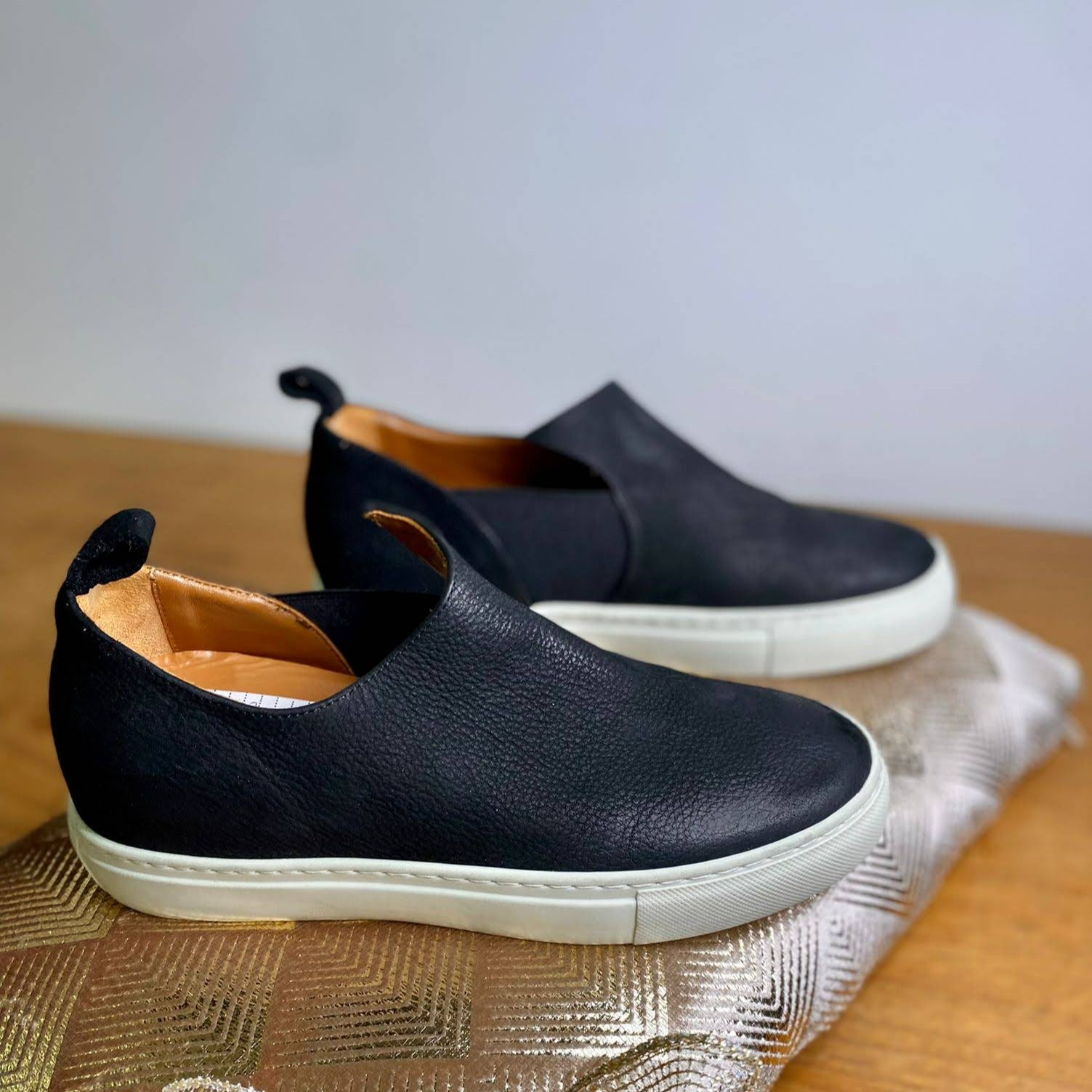 SNEAKERS MODELLO SLIP-ON IN MORBIDISSIMO NABUK INGRASSATO NERO. TOMAIA CON TAGLIO ASIMMETRICO NEL DETTAGLIO DELL'ELASTICO. FONDO A CASSETTA IN GOMMA BIANCA LEGGERISSIMA. FUSSBETT RICOPERTO IN PELLE ESTRAIBILE CON RIALZO INTERNO SUL TALLONE DI 3 CM. CALZATA REGOLARE E COMODA. TOMAIA - FODERA - SOTTOPIEDE IN PELLE 100%.