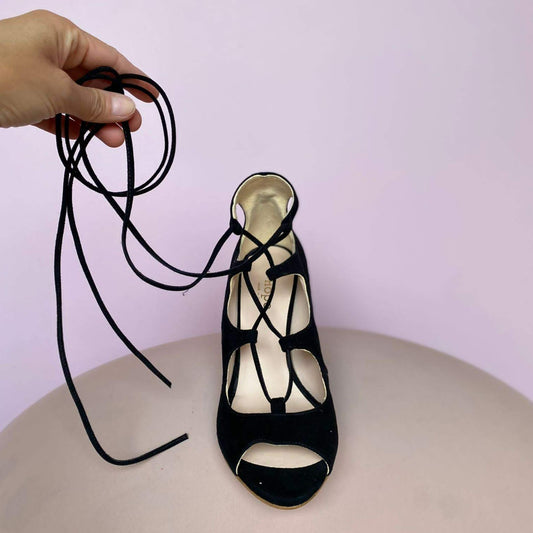 DÉCOLLETÉ OPEN TOE IN CAMOSCIO NERO CON LACCI CHE CINGONO IL PIEDE E LA CAVIGLIA: O SEMPLICEMENTE GHILLIES. SOTTOPIEDE IMBOTTITO DI 3 MM E FODERA IN PELLE. COMODO TACCO 7 CM. TOMAIA - FODERA - SOTTOPIEDE IN PELLE 100%. PELLAMI ITALIANI DI QUALITÀ. FONDO IN CUOIO RIGENERATO. PRODOTTO IN ITALIA, MARCHE