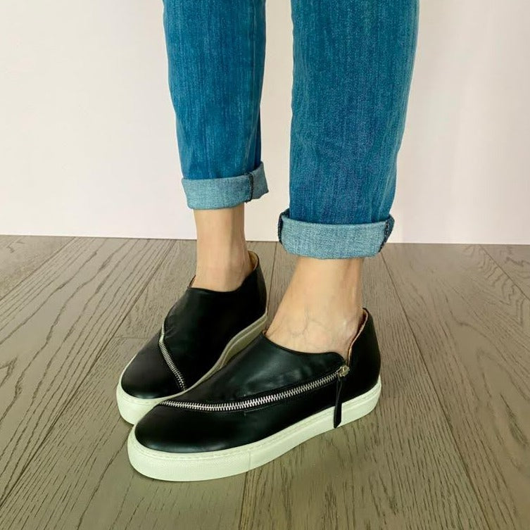 SNEAKERS SLIP-ON NERA CON CERNIERA. TOMAIA IN MORBIDISSIMO NABUK INGRASSATO NERO, DALLA FORMA LINEARE E CONTEMPORA GRAZIE ALLA LUNGA CERNIERA IN ACCIAIO CHE TAGLIA LA TOMAIA. FONDO A CASSETTA IN GOMMA BIANCA LEGGERISSIMA. FUSSBETT ESTRAIBILE RICOPERTO IN PELLE CON RIALZO INTERNO SUL TALLONE DI 3 CM. CALZATA COMODA. SE HAI DUBBI, CONTATTACI VIA SMS O WHATSAPP AL 351/8950405 TI CONSIGLIEREMO NELLA SCELTA. TOMAIA - FODERA - SOTTOPIEDE IN PELLE 100%. PELLAMI ITALIANI DI QUALITÀ. PRODOTTO IN ITALIA, MARCHE
