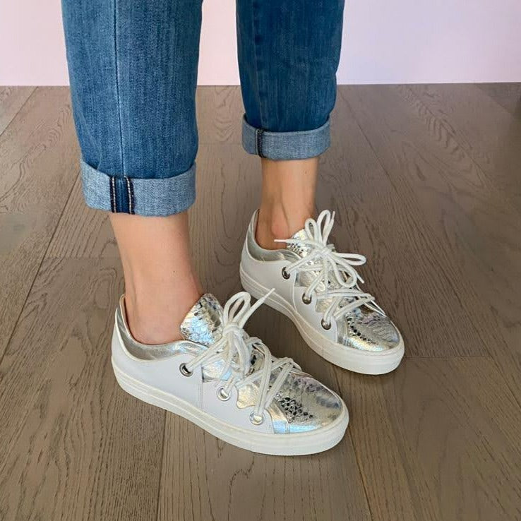 SNEAKERS ALLACCIATA IN MORBIDA NAPPA BIANCA CON BORDATURA E LINGUETTA IN NAPPA ARGENTO LAMINATO A SPECCHIO CON STAMPA PITONE. PASSALACCI IN METALLO ARGENTO SATINATO. FONDO A CASSETTA IN GOMMA COLOR CIPRIA LEGGERISSIMO. FUSSBETT ESTRAIBILE RICOPERTO IN PELLE CON RIALZO INTERNO SUL TALLONE DI 1,5 CM. CALZATA COMODA. SE HAI DUBBI, CONTATTACI VIA SMS O WHATSAPP AL 351/8950405 TI CONSIGLIEREMO NELLA SCELTA. TOMAIA - FODERA - SOTTOPIEDE IN PELLE 100%. PELLAMI ITALIANI DI QUALITÀ. PRODOTTO IN ITALIA, MARCHE