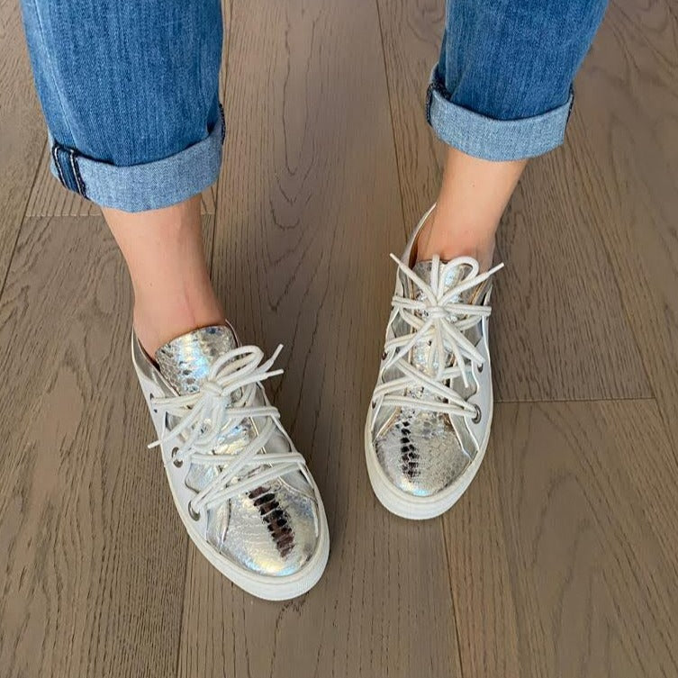 SNEAKERS ALLACCIATA IN MORBIDA NAPPA BIANCA CON BORDATURA E LINGUETTA IN NAPPA ARGENTO LAMINATO A SPECCHIO CON STAMPA PITONE. PASSALACCI IN METALLO ARGENTO SATINATO. FONDO A CASSETTA IN GOMMA COLOR CIPRIA LEGGERISSIMO. FUSSBETT ESTRAIBILE RICOPERTO IN PELLE CON RIALZO INTERNO SUL TALLONE DI 1,5 CM. CALZATA COMODA. SE HAI DUBBI, CONTATTACI VIA SMS O WHATSAPP AL 351/8950405 TI CONSIGLIEREMO NELLA SCELTA. TOMAIA - FODERA - SOTTOPIEDE IN PELLE 100%. PELLAMI ITALIANI DI QUALITÀ. PRODOTTO IN ITALIA, MARCHE
