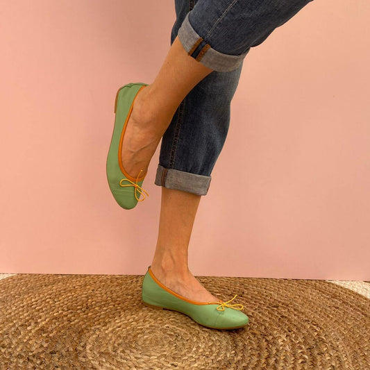 CLASSICHE BALLERINE FLAT A PUNTA TONDA IN NAPPA VERDE ACQUA CON PUNTALE SEGNATO. LA MORBIDA SCOLLATURA È IMPREZIOSITA DA UNA BORDATURA IN TESSUTO DI GROS GRAIN ARANCIO. IL FIOCCHETTO IN PUNTA È GIALLO. IL PROFILO IN TESSUTO MANTIENE LA SCARPA FERMA ATTORNO AL PIEDE. MORBIDE E MOLTO COMODE GRAZIE ALLA FLESSIBILE SUOLA IN GOMMA, SOTTOPIEDE E FODERA IN PELLE. CALZATA REGOLARE. TOMAIA - FODERA - SOTTOPIEDE IN PELLE 100%. PRODOTTO IN ITALIA, MARCHE DA LE TRALLERINE.