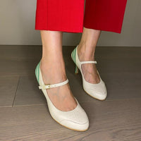 DÉCOLLETÉ BICOLORE IN MORBIDA NAPPA PANNA E DECORAZIONI IN NAPPA ACQUA. PUNTA ROTONDA E UN SOTTILE CINTURINO ALLA CAVIGLIA, MOLTO BON TON, CHE ASSICURA LA SCARPA AL PIEDE NELLA CAMMINATA. CALZATA REGOLARE CHE ABBRACCIA BENE IL PIEDE. SOTTOPIEDE IMBOTTITO DI 3 MM E FODERA IN PELLE. TACCO 7 CM. TOMAIA - FODERA - SOTTOPIEDE IN PELLE 100%. PELLAMI ITALIANI DI QUALITÀ. FONDO CUOIO RIGENERATO. CINTURINO REGOLABILE CON FIBBIA. PRODOTTO IN ITALIA, MARCHE DA HOPE.