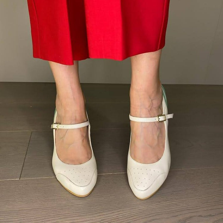 DÉCOLLETÉ BICOLORE IN MORBIDA NAPPA PANNA E DECORAZIONI IN NAPPA ACQUA. PUNTA ROTONDA E UN SOTTILE CINTURINO ALLA CAVIGLIA, MOLTO BON TON, CHE ASSICURA LA SCARPA AL PIEDE NELLA CAMMINATA. CALZATA REGOLARE CHE ABBRACCIA BENE IL PIEDE. SOTTOPIEDE IMBOTTITO DI 3 MM E FODERA IN PELLE. TACCO 7 CM. TOMAIA - FODERA - SOTTOPIEDE IN PELLE 100%. PELLAMI ITALIANI DI QUALITÀ. FONDO CUOIO RIGENERATO. CINTURINO REGOLABILE CON FIBBIA. PRODOTTO IN ITALIA, MARCHE DA HOPE.