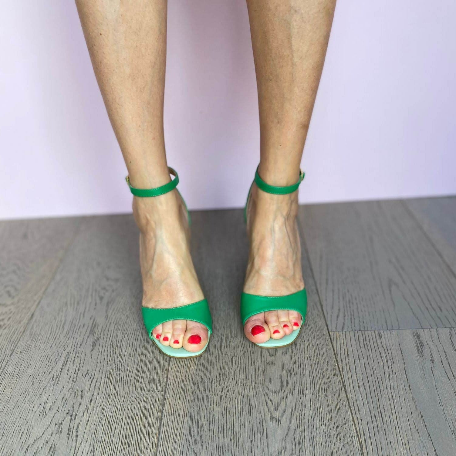 Sandalo in pelle bicolore verde con tacco medio di 5 cm e cinturino alla caviglia.